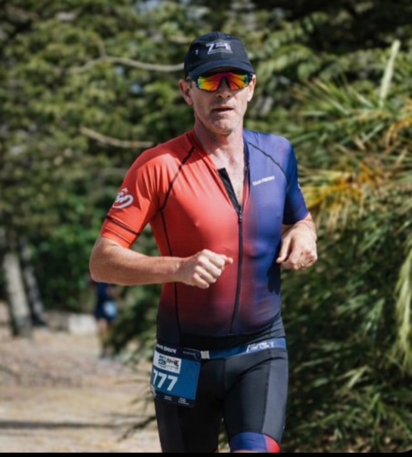 Coach Trindall racing on the run leg of a triathlon